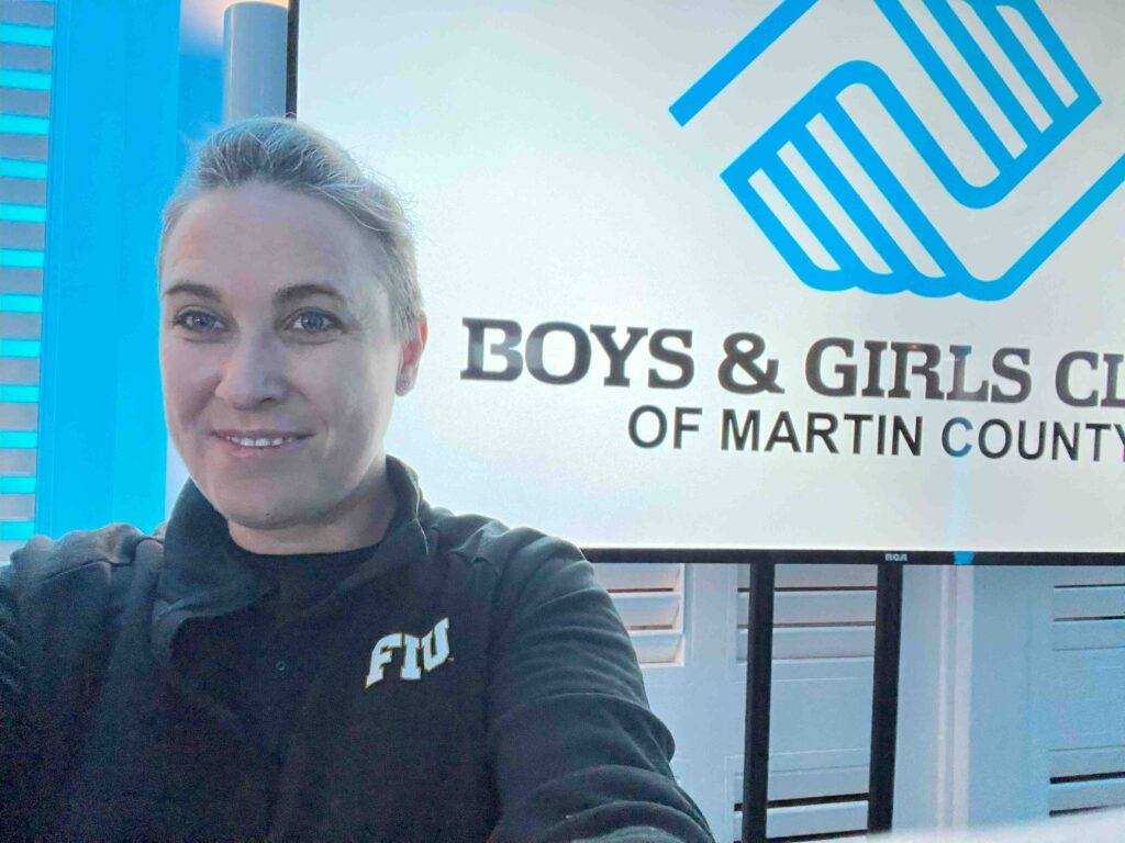 Fundraiser video production expert Jessica Kizorek posing in front of the Boys & Girls Club of Martin County sign.