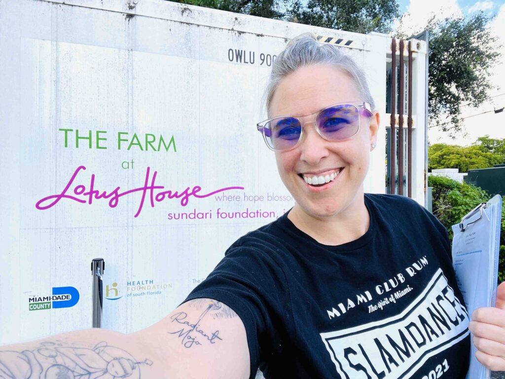Jessica Kizorek posing with the Lotus House logo in the background.