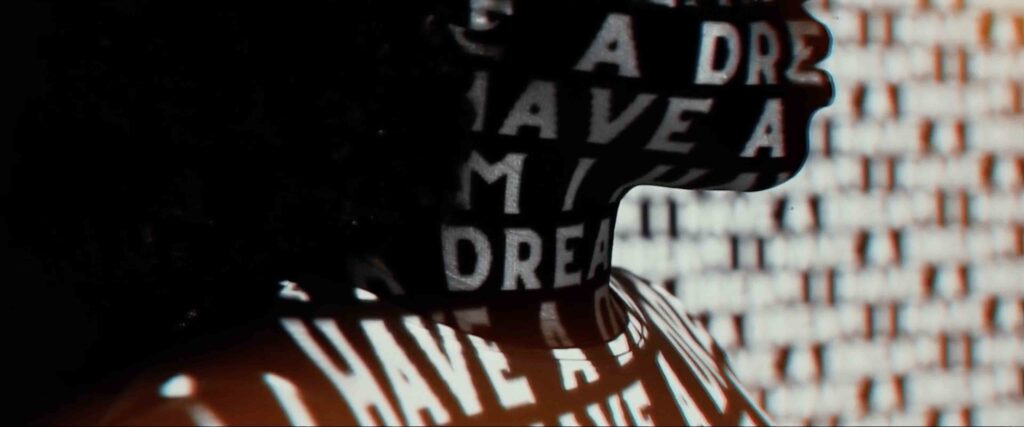 A young black woman has the Reverend Dr. Martin Luther King Jr.’s famous “I Have a Dream” words projected onto her.