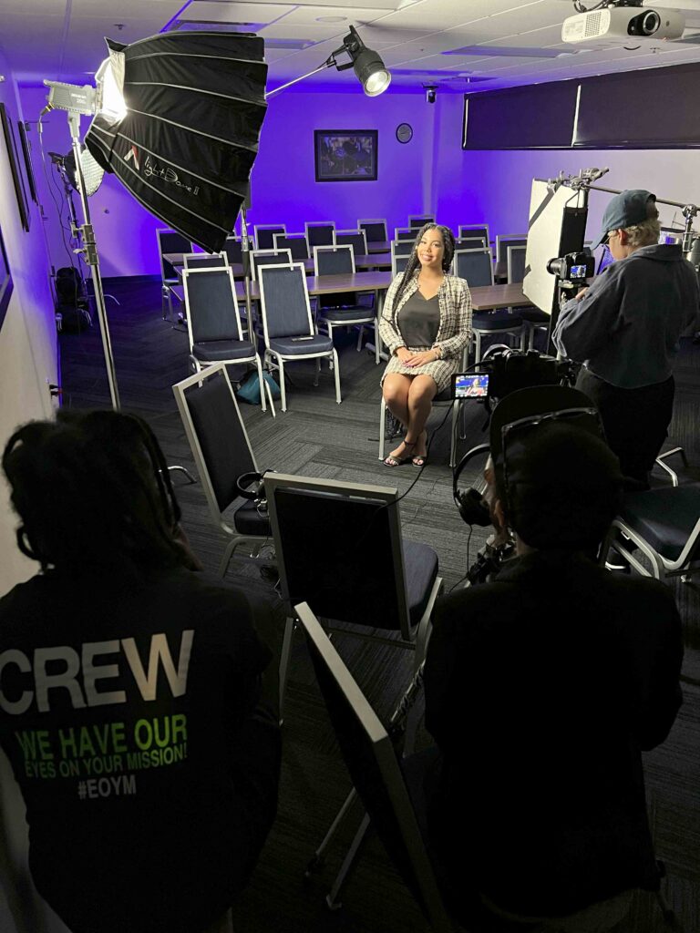 Behind the scenes of an educational fundraising video production with an FIU Eyes on Your Mission team member in a classroom, waiting to tell her story.