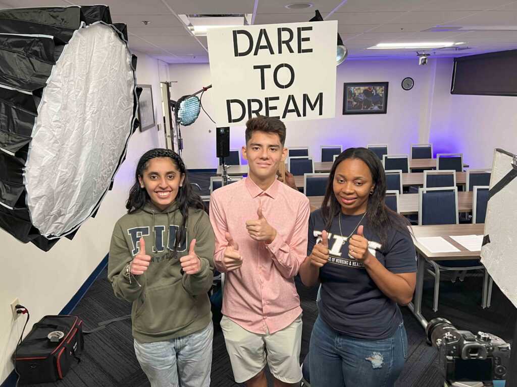 FIU MLK essay winners smiling and holding a “Dare to Dream” sign.